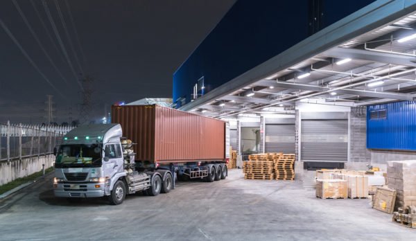 Woman carrying a cardboard box in a warehouse